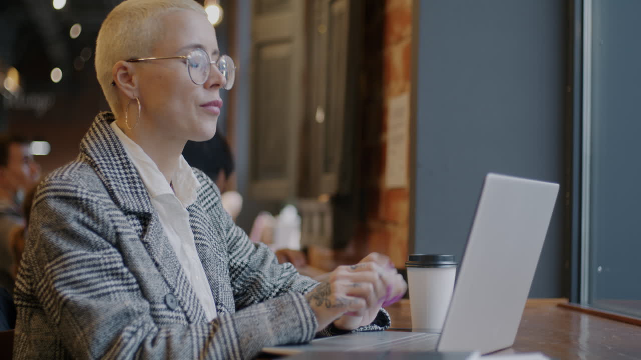 Woman Working on Laptop in Cafe