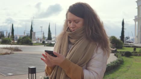 woman using phone in a city park