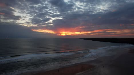 Drone-flying-at-dusk-over-Freshwater-West-Beach-showing-a-sunset-like-a-fire-ball