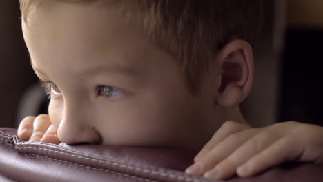 niño balanceándose en la silla de brazo