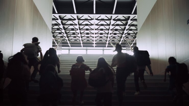 Teenage students running upstairs in school corridor. Crowd pupils leave campus.
