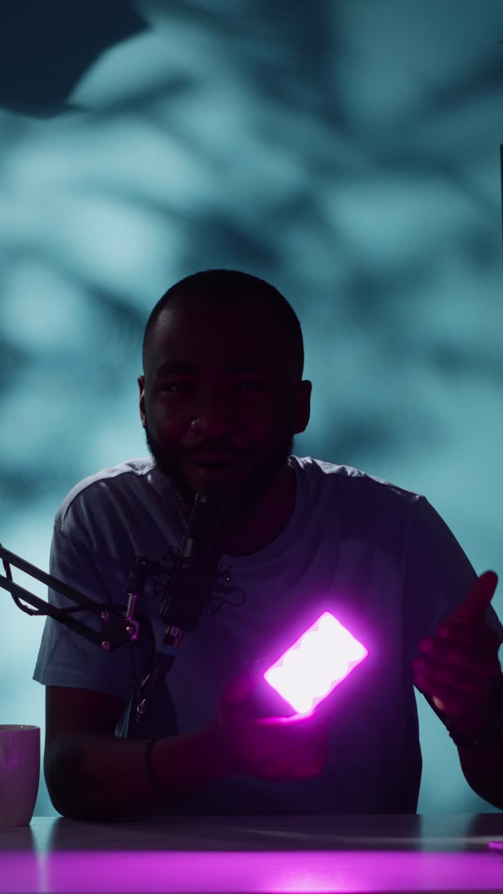 Uomo che registra un podcast con microfono e luce