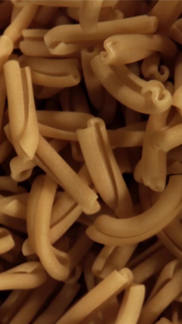 Primo piano di pasta maccheroni secca cruda.