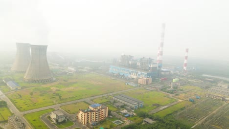 drone shot of indian factories, with heavy smoke clouds polluting the air from towering stacks.