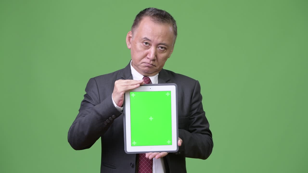 디지털 태블릿을 보여주는 성숙한 일본 사업가