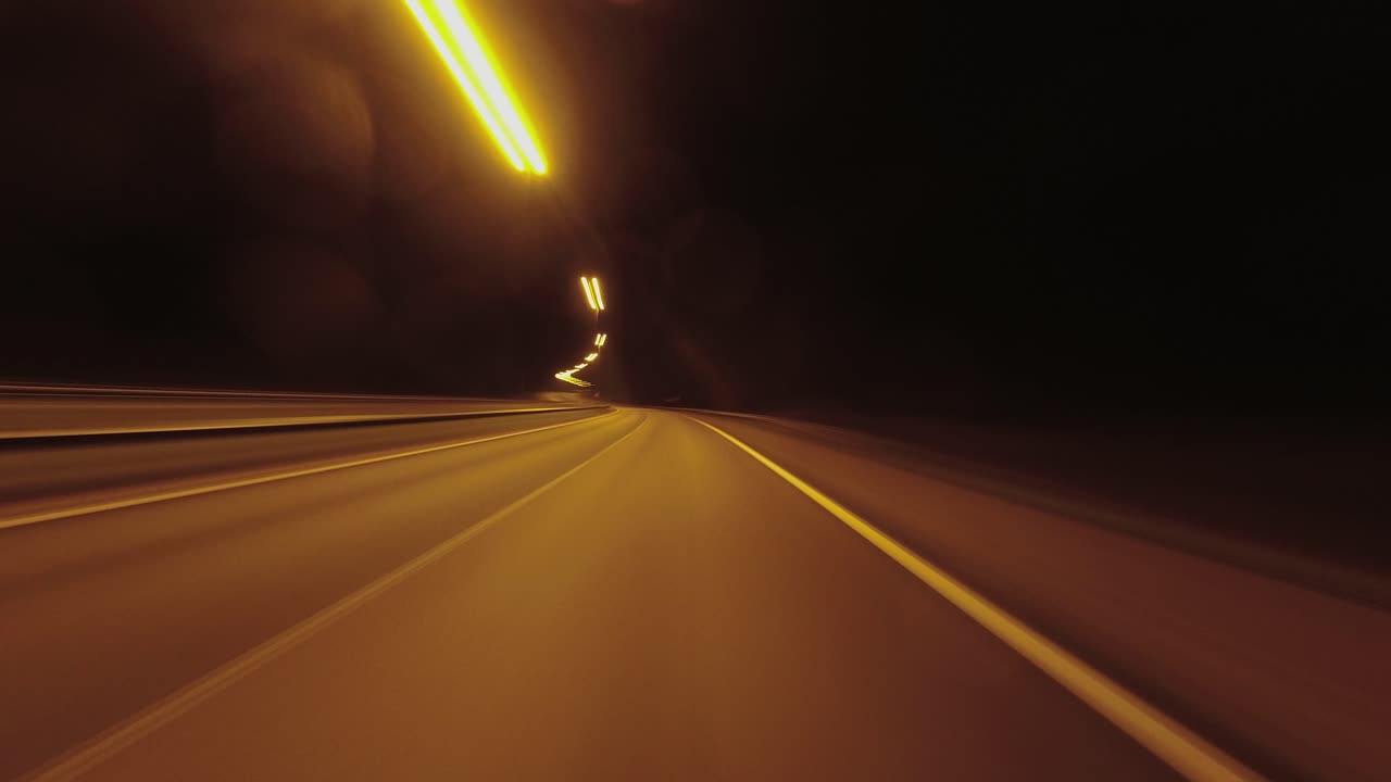 Hypnotic night hyperlapse POV: Driving illuminated highway at night