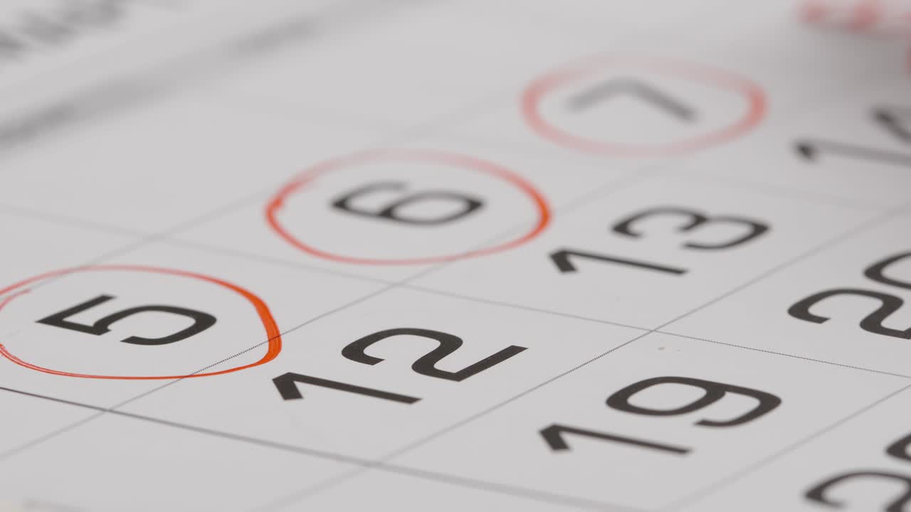 de cerca: marcando (una ronda) un número en un calendario de papel