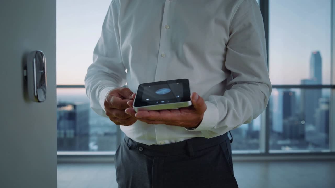 Tapping man in white shirt using tablet in office near door lock, windows, showing circular display