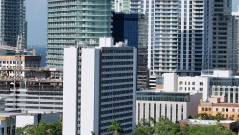 aerial rising shot of modern residential skyscraper in downtown of saint petersburg, florida. zoom shot. luxury houses and urbans during sunny day. bay water in distance.
