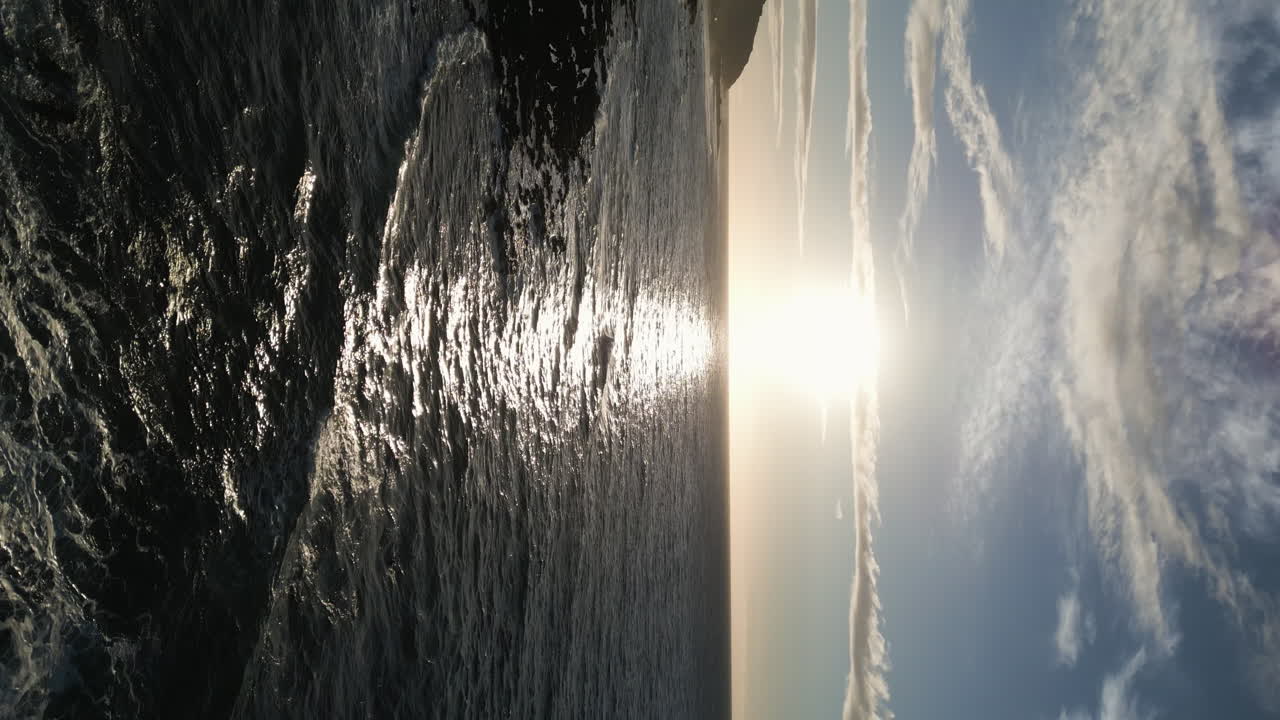 дрон спускается по освещенному восходом солнца берегу песчаного пляжа в оаху, гавайи