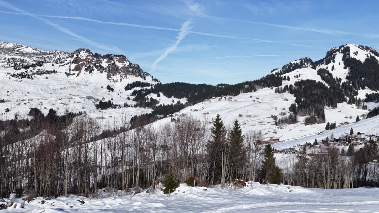 Aerial view of the snow-covered Churfirsten mountains and Amden village in Switzerland. Majestic winter landscape conveying peace, freedom, and quiet solitude