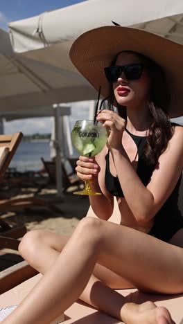 woman enjoying a gin and tonic on the beach