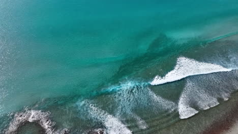 aerial view of coastline with turquoise water and waves