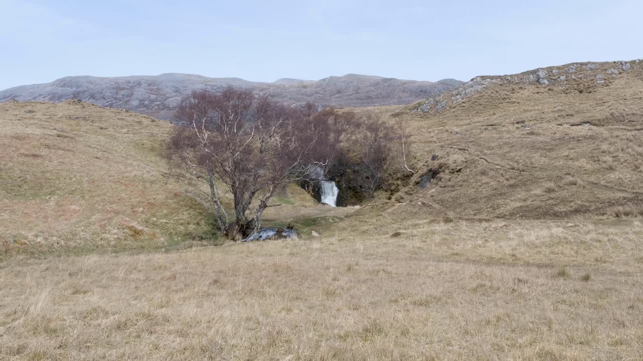 vista panorámica de la cascada del castillo de ardvreck que fluye libremente en el desierto al aire libre de las tierras altas de escocia, reino unido