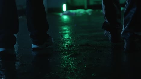 men walk on a wet street with light reflection on the street