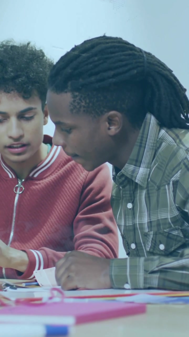 In school, diverse group collaborating on creative animation project at table