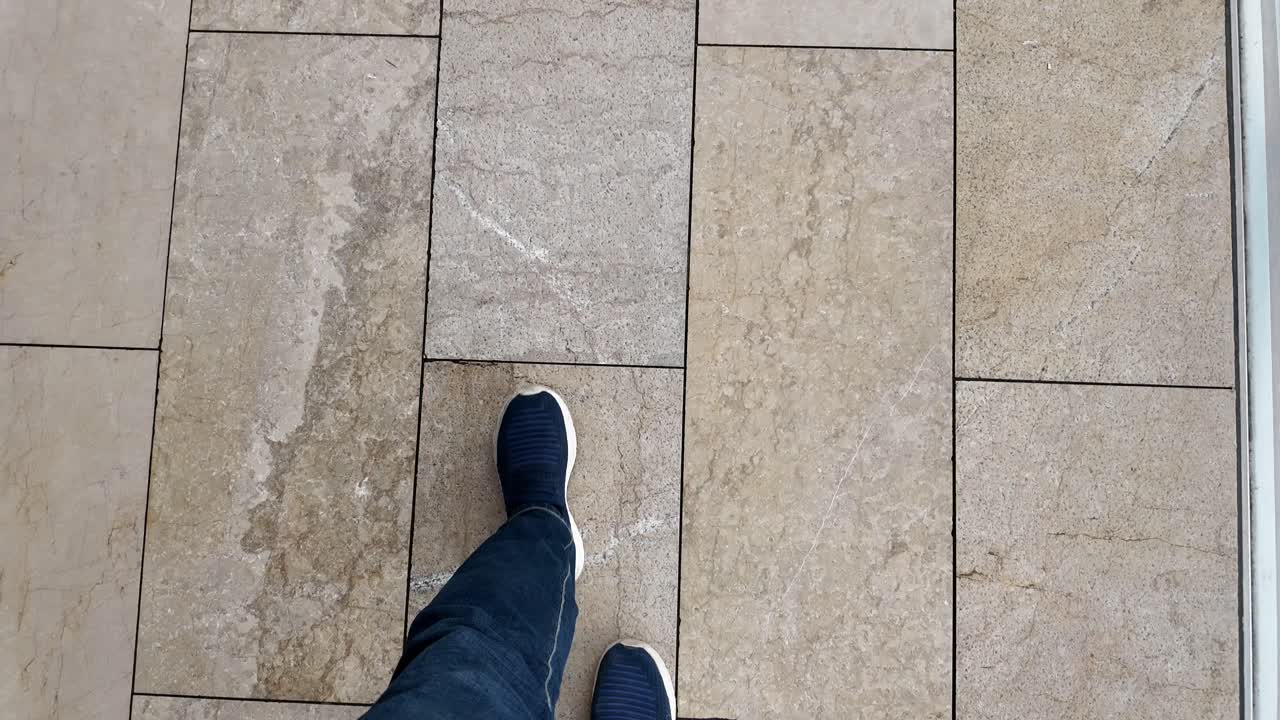 Person walking on a tiled floor