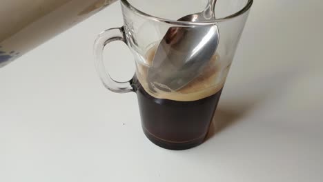 transparent glass filled half with black coffee