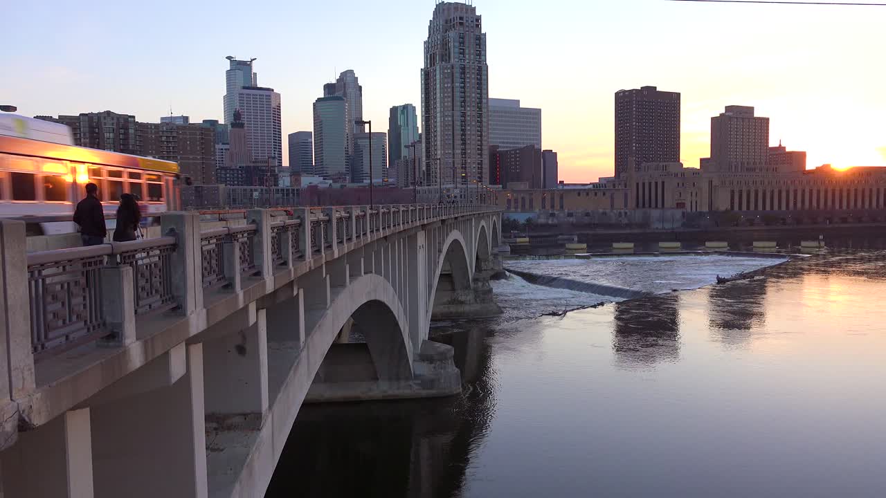 una toma al atardecer del centro de minneapolis minnesota con el río mississippi en primer plano
