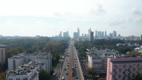 Descending-footage-of-vehicles-driving-on-wide-straight-street-in-town.-Transport-in-city.-Warsaw,-Poland