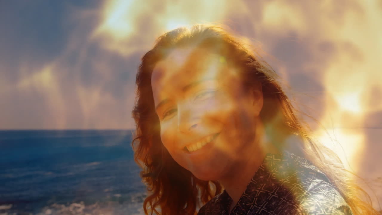 By ocean, person smiling with warm, glowing light animation overlay