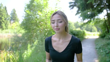 una mujer disfrutando de su trote alrededor de un estanque en un parque en un día de verano perfecto