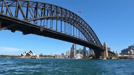 Sydney-Harbour-Bridge-and-Opera-House-on-a-clear-day,-city-skyline,-from-water