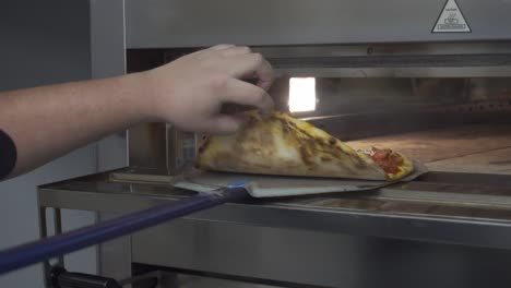 pizza chef checks on a pizza before putting it into the oven