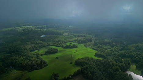 Aerial-view-of-clouds-slowly-covering-a-green-landscape