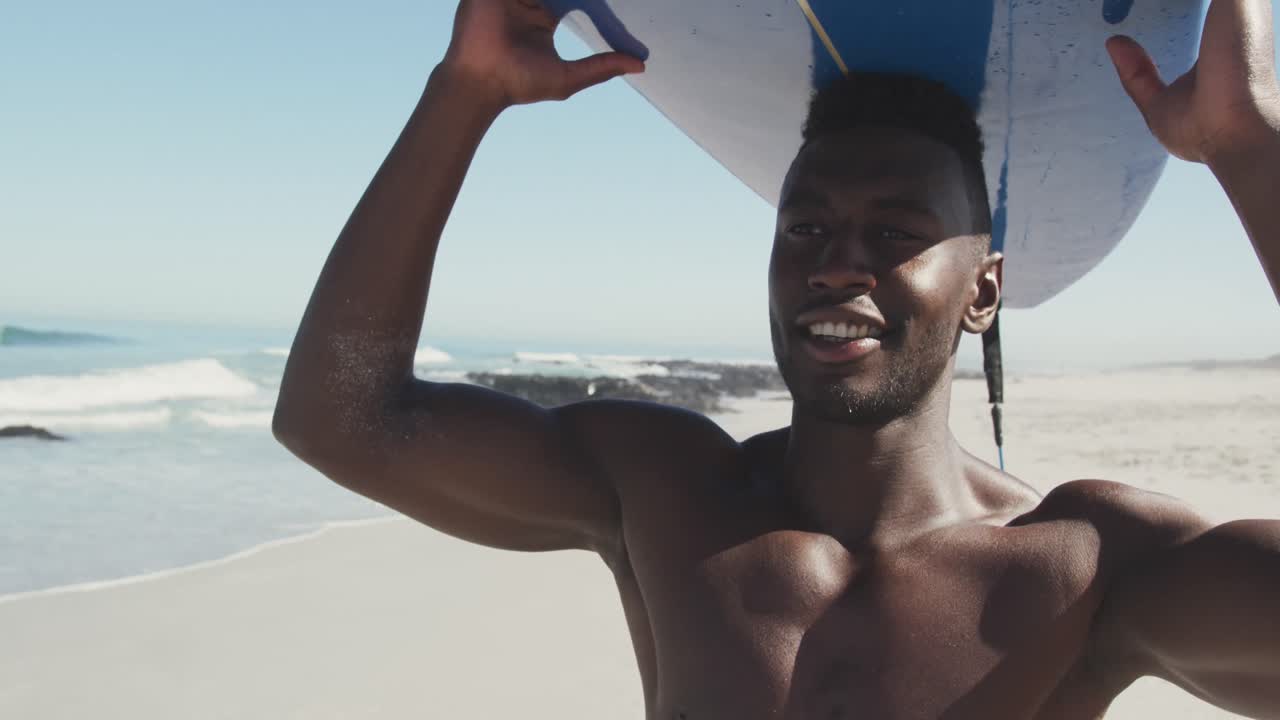 아프리카계 미국인 남자가 머리에 서프보드 를 들고 있다