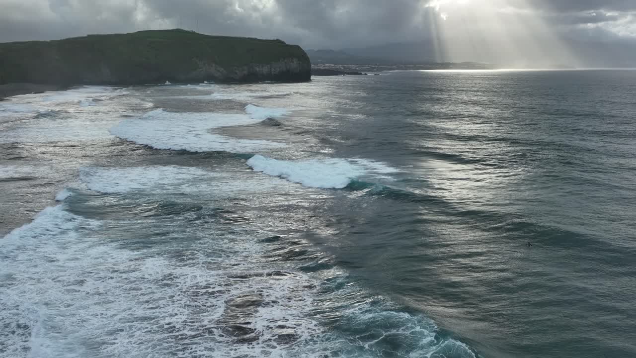 Waves roll out onto Santa Barbara beach, São Miguel, Azores. Sunset aerial slomo