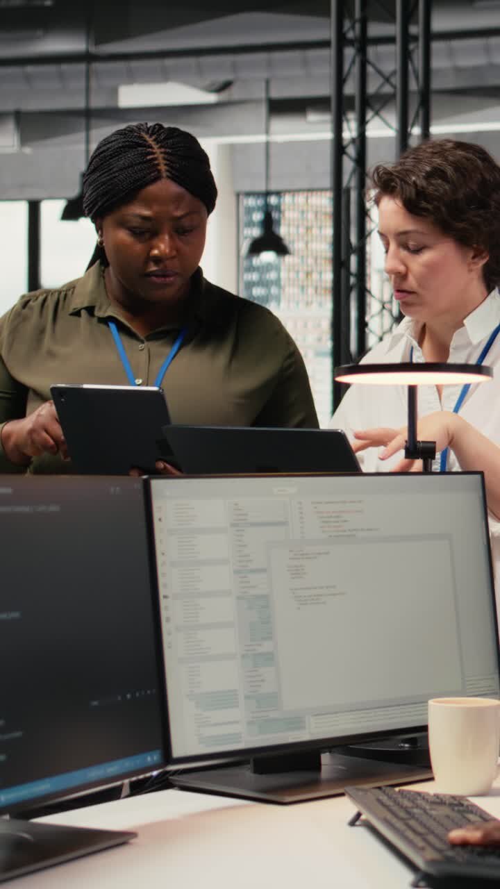 Vertical video Female engineers in startup office using AI technology driving market innovation