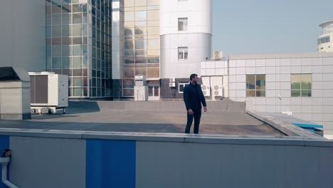 upper-view-young-man-stands-on-modern-factory-roof