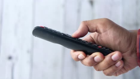 hand holding a black remote control