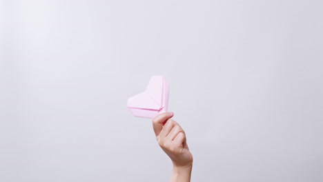 Woman's-holding-a-paper-heart-in-white-studio-background-with-copy-space