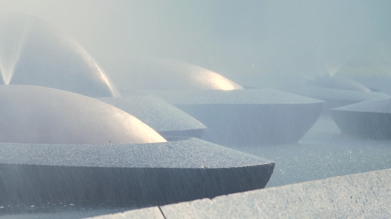 View on water splashing from fountain â€œSun Boatsâ€ in JaunpilsÄ“tas Square in Ventspils in sunny summer day, closeup shot