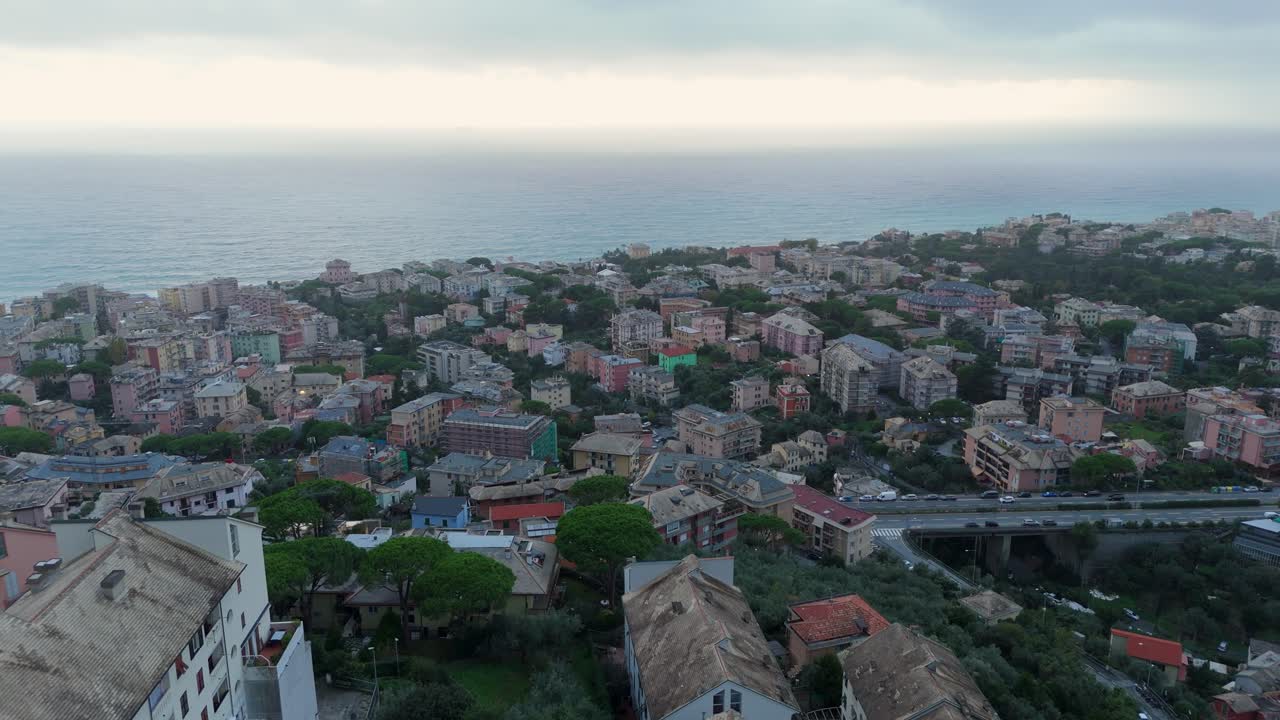 Coastal italian town with colorful buildings overlooking the sea on an overcast day, aerial view