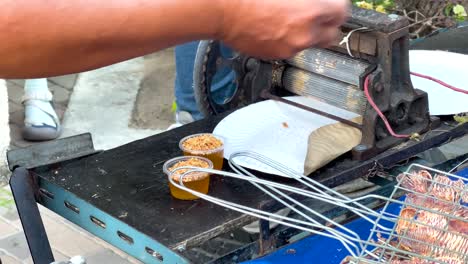 vendedor callejero de comida preparando pescado a la parrilla