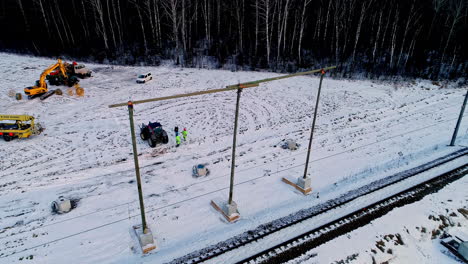 aerial view of worker repairing overhead wire on railroad during snowy day