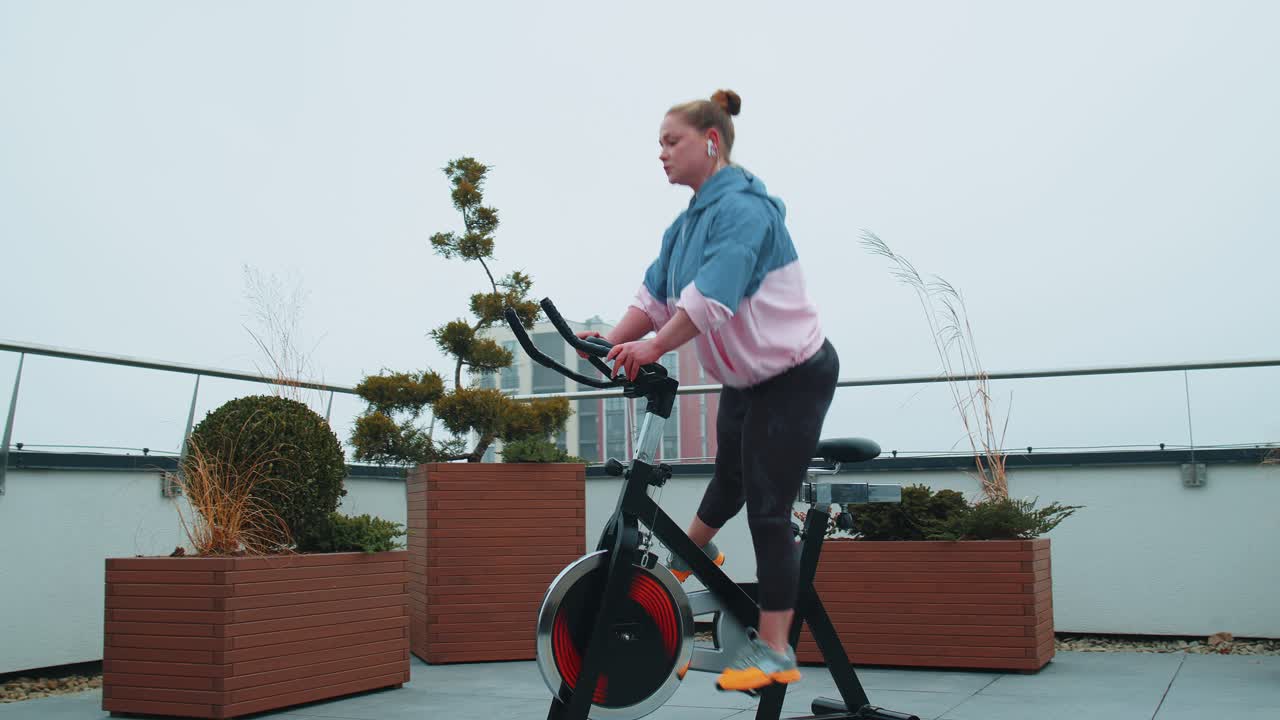 Woman performs aerobic endurance training workout cardio routine on the simulators cycle training