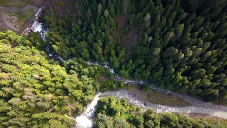 the confluence of two streams in the dolomite mountains of northern italy, aerial drone pedestal down shot