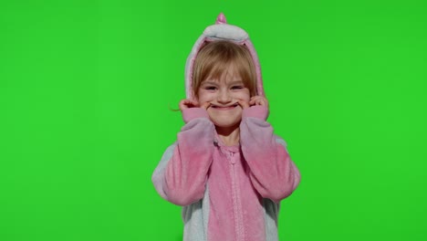 Child-girl-in-unicorn-pajamas-making-silly-funny-faces,-fooling-around,-showing-tongue-on-chroma-key