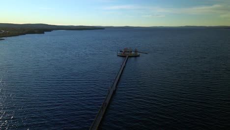 Long-Footbridge-in-Blue-Sea,-Circle-Shot,-Aerial