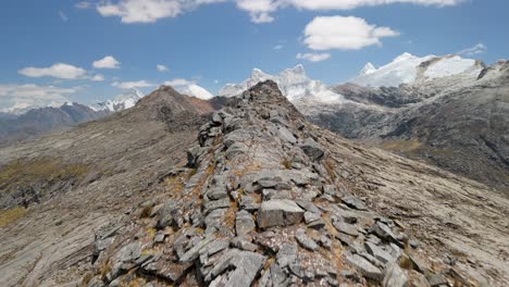 fast aerial drone shot flying closely over a jagged rocky ridge on the santa cruz trek in the peruvian andes