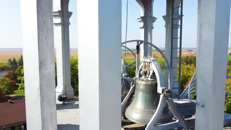 Flying-over-the-bell-mechanism-of-a-church-tower-towards-beautifully-colored-autumn-trees