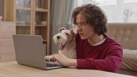 man working at computer with dog