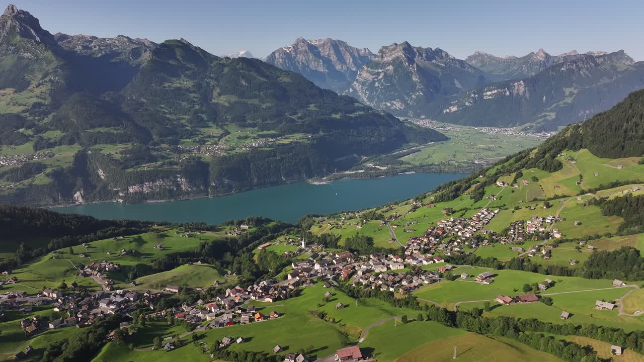 Aerial View of a Scenic Swiss Village, Lake, and Alpine Mountains