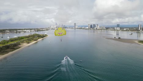 popular holiday tourist activities on a busy waterway with an urban city skyline in the distance