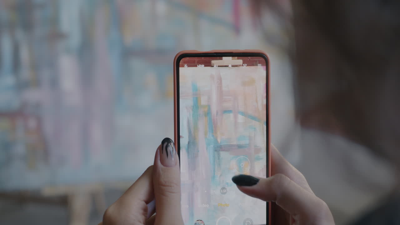 Woman taking photo of art display with mobile phone