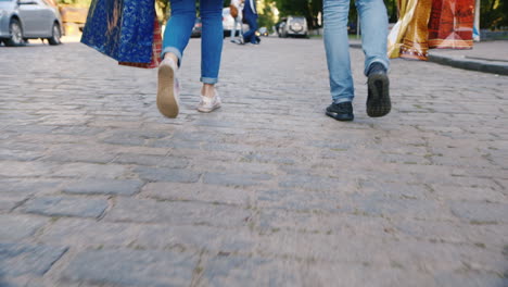 man and woman are on the sidewalk with shopping bags in the picture can be seen only the legs back v